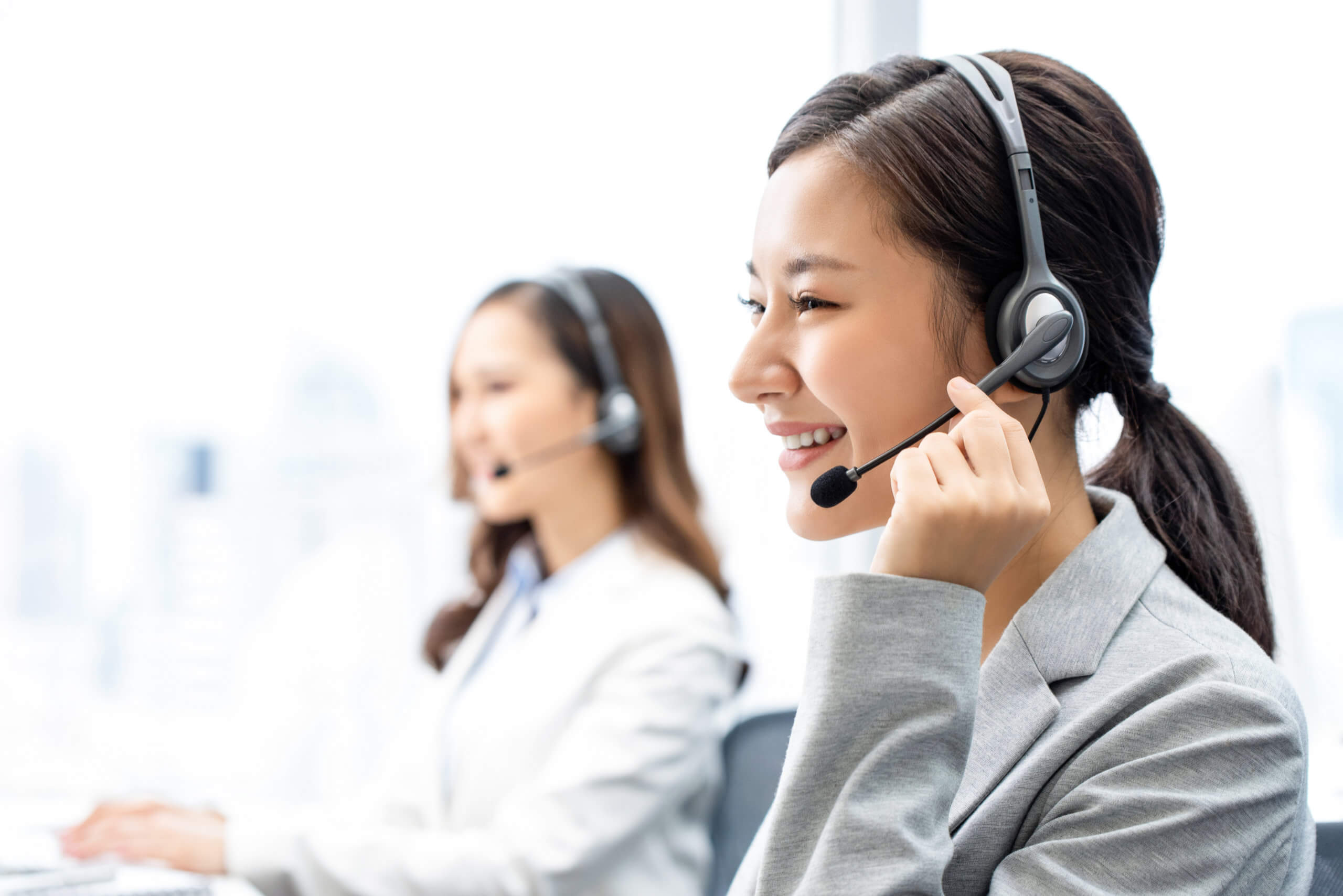 Woman with Headphones in Call Center Smiling