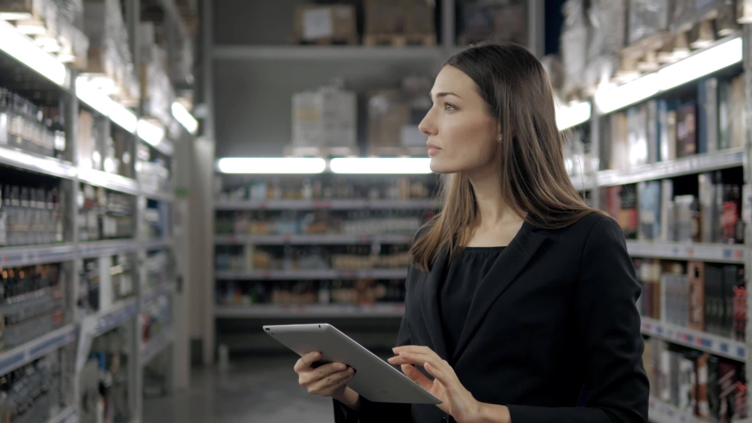 Woman in corporate attire doing inventory in tablet