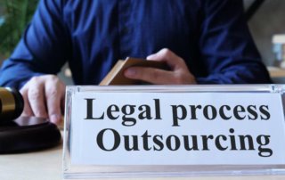 A sign on an office table reads legal process outsourcing.