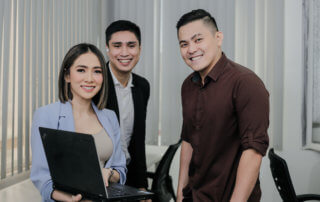 Three executives of a Chinese call center are smiling to the camera.