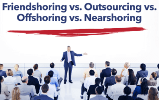 The words outsourcing vs. offshoring vs. nearshoring are written on a board behind an executive.