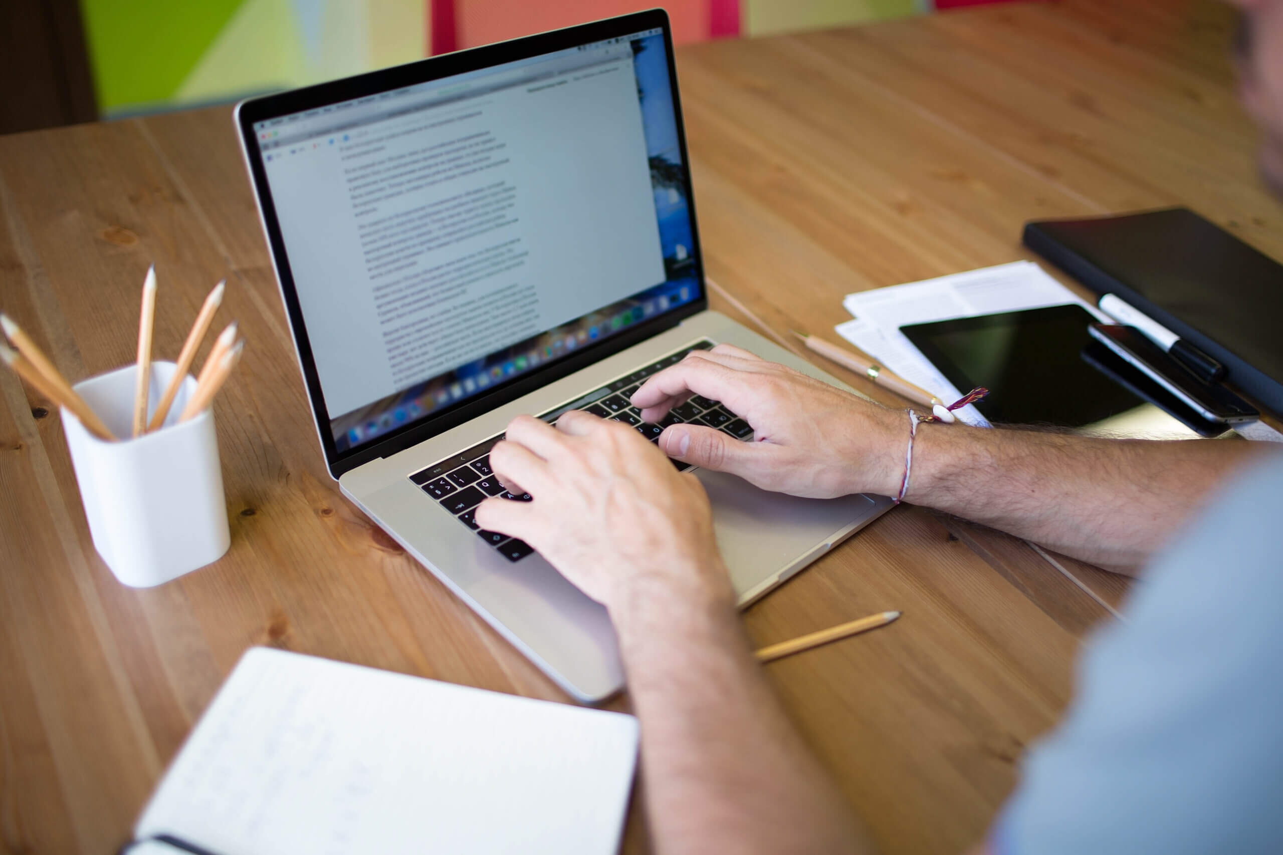 A man who provides content writing outsourcing services is working on his laptop.