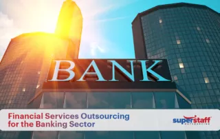 An image shows a bank building. The text reads Why Banking Sector Should Outsource Financial Services.