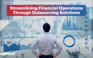 An accounting professional stands in front of a screen filled with charts and graphs. Also in the image is the text, "Streamlining Financial Operations Through Outsourcing Solutions."