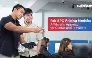 The image shows two employees discussing in the workplace. In a textbox is the title of the blog, "Fair BPO Pricing Models: A Win-Win Approach for Clients and Providers."