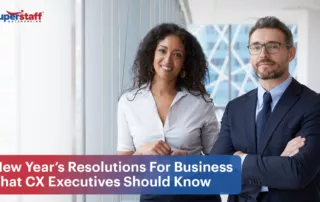 Two executives smile while standing next to each other. Image captions says: New Year’s Resolutions For Business That CX Executives Should Know.