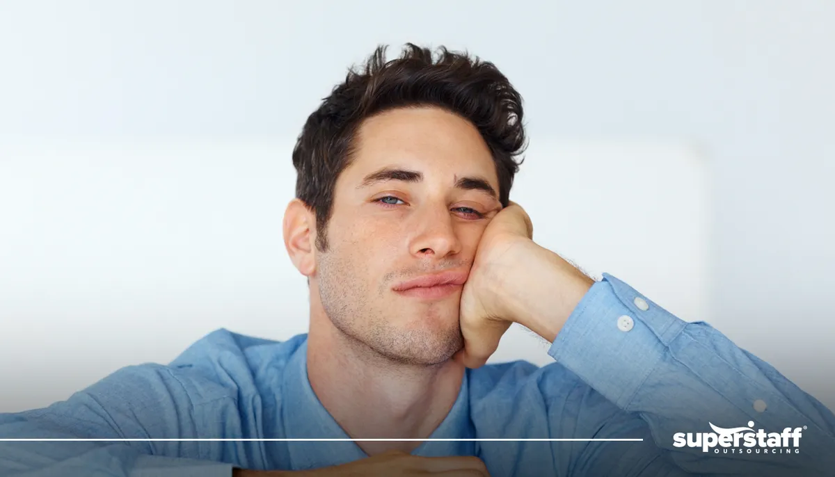 A photo shows a man cupping his chin out of boredom. 