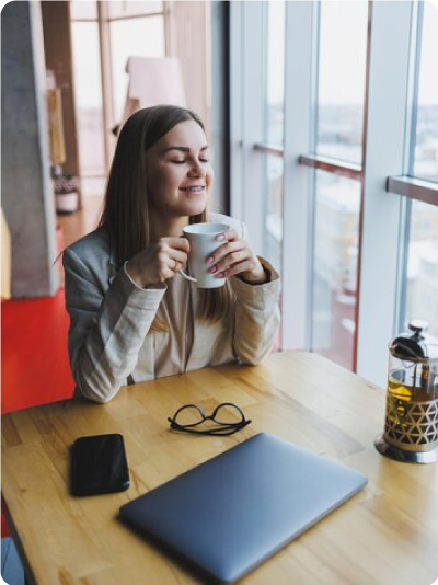 A financial outsourcing services executive drinks coffee by the window.