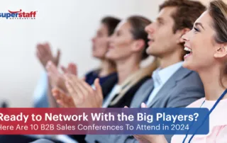 Executives in the audience are clapping. Image caption reads: Here Are 10 B2B Sales Conferences Worth Attending in 2024