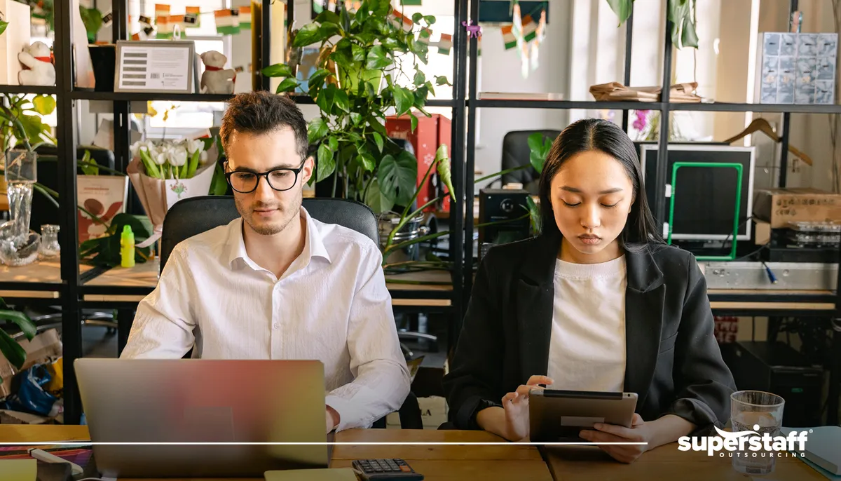 Photo shows two colleagues work side by side.